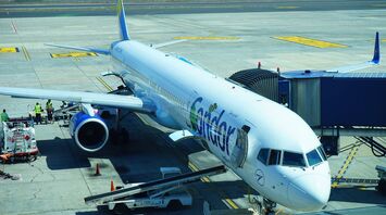 Condor's plane parked at the gate with ocean in the background