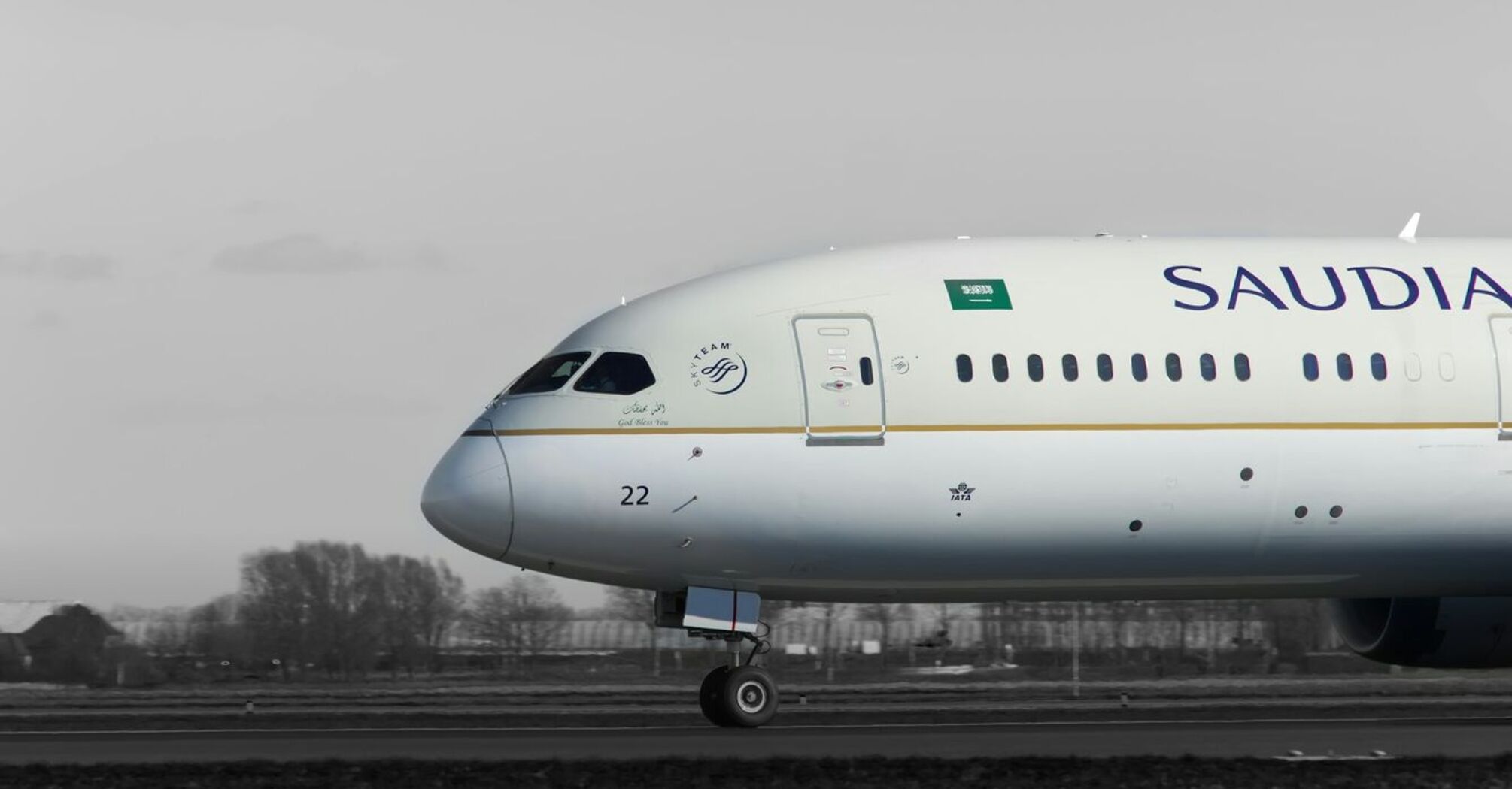 Saudia airline aircraft taxiing on runway with cloudy background