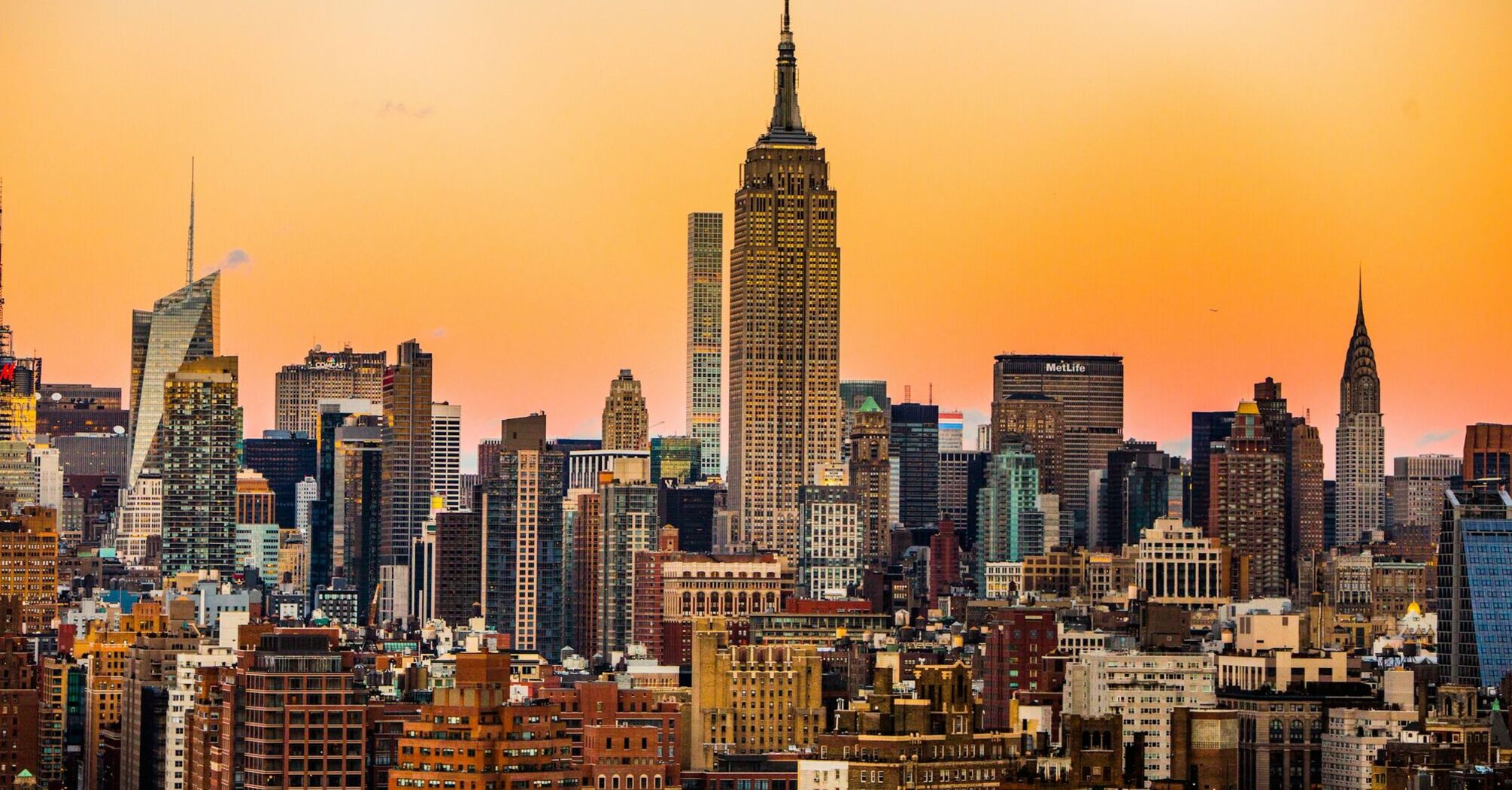 Skyline of New York City during sunset with prominent buildings including the Empire State Building