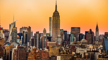 Skyline of New York City during sunset with prominent buildings including the Empire State Building