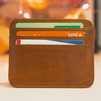 A brown leather wallet holding multiple credit cards
