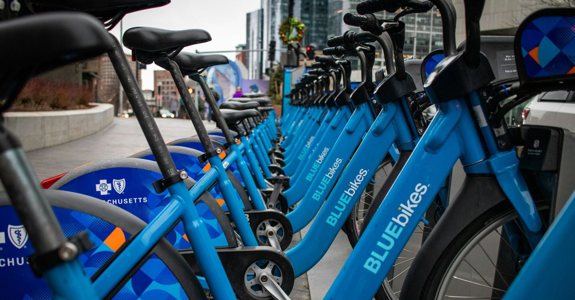 Row of blue Blue Bikes docked at a station in Boston, Massachusetts