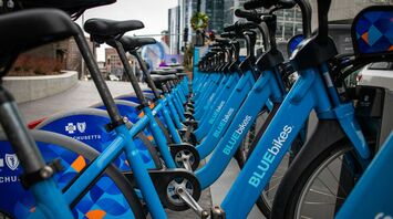 Row of blue Blue Bikes docked at a station in Boston, Massachusetts