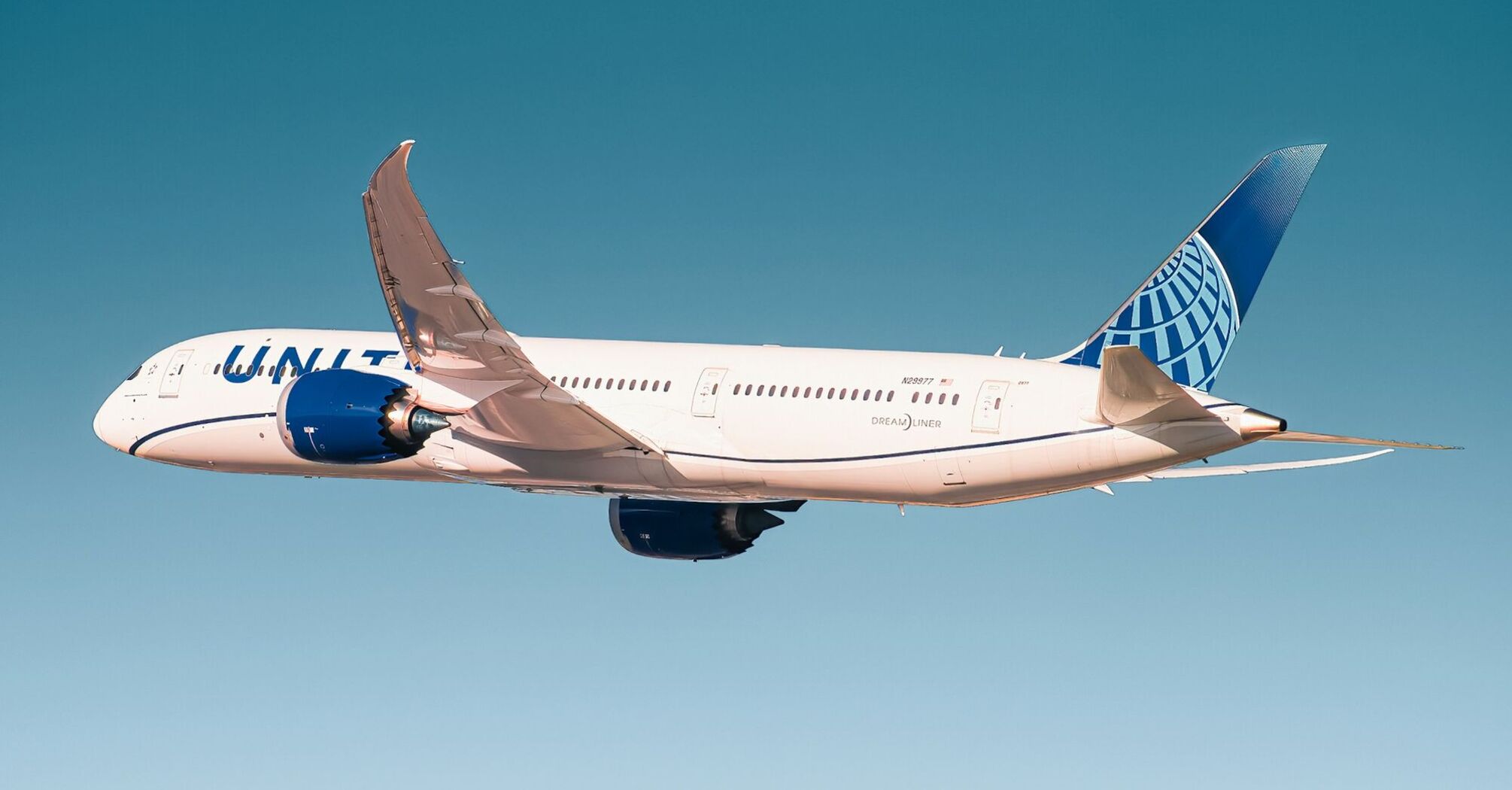 United Airlines Boeing in flight against a clear blue sky