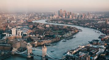 Aerial view of London showcasing the River Thames and iconic landmarks such as the Tower Bridge and Canary Wharf