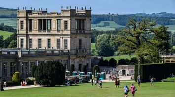 People in green grass field near beige concrete building during daytime in Derbyshire