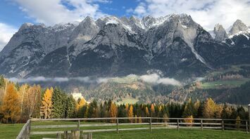 Brown wooden bench near trees and mountains during daytime in Werfen