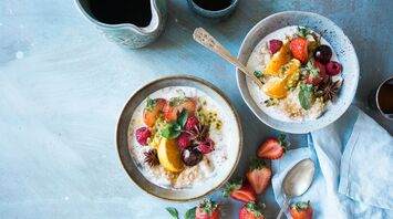 A vibrant breakfast spread featuring overnight oats topped with fresh strawberries