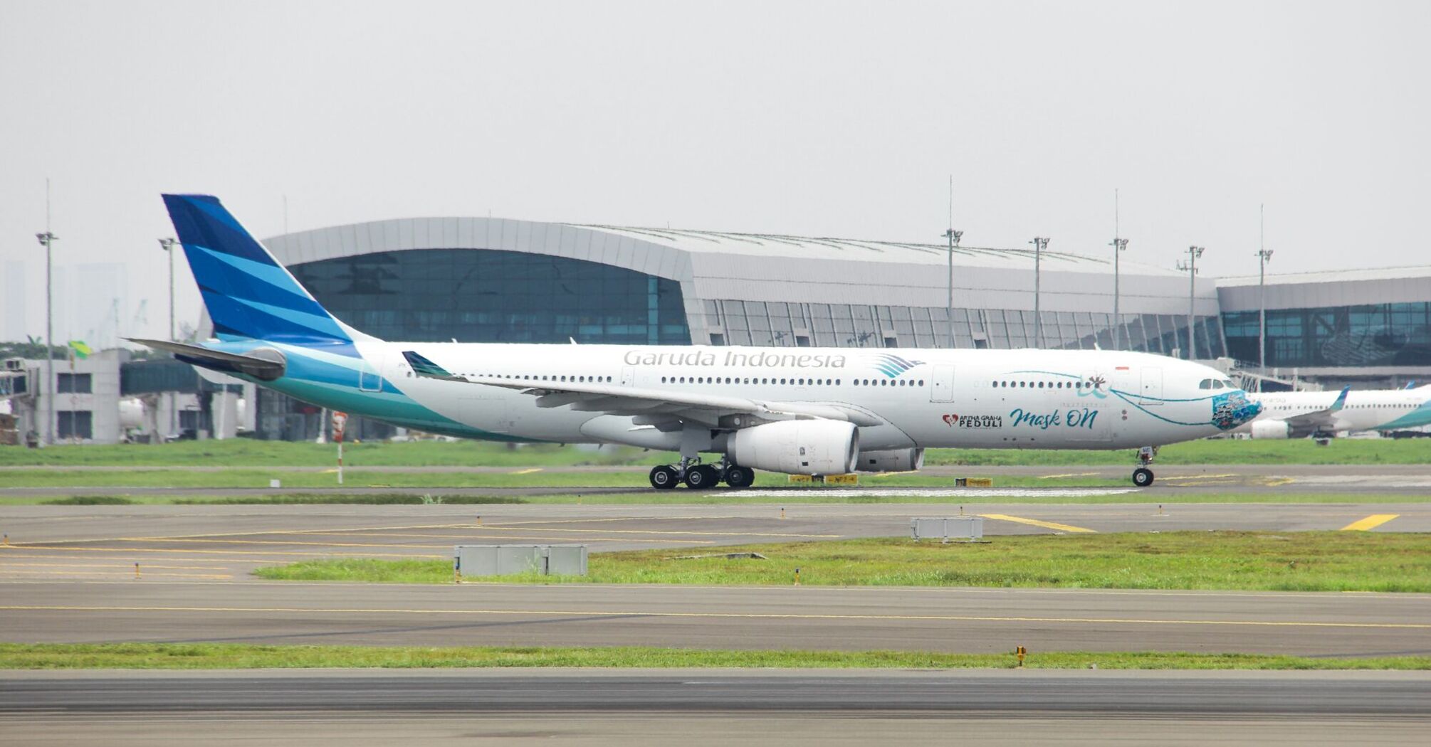 A large Garuda Indonesia passenger jet sitting on top of an airport runway