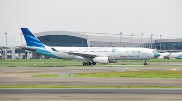 A large Garuda Indonesia passenger jet sitting on top of an airport runway