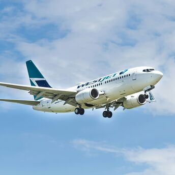 WestJet airplane in flight against a blue sky