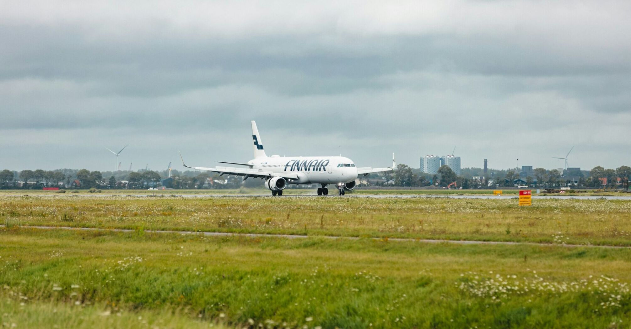 Finnair airplane landing on a runway with urban skyline