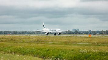 Finnair airplane landing on a runway with urban skyline