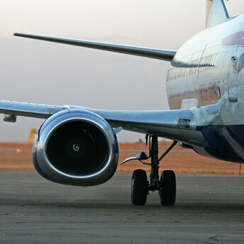 Close-up of an airplane engine and landing gear on the runway