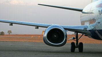 Close-up of an airplane engine and landing gear on the runway