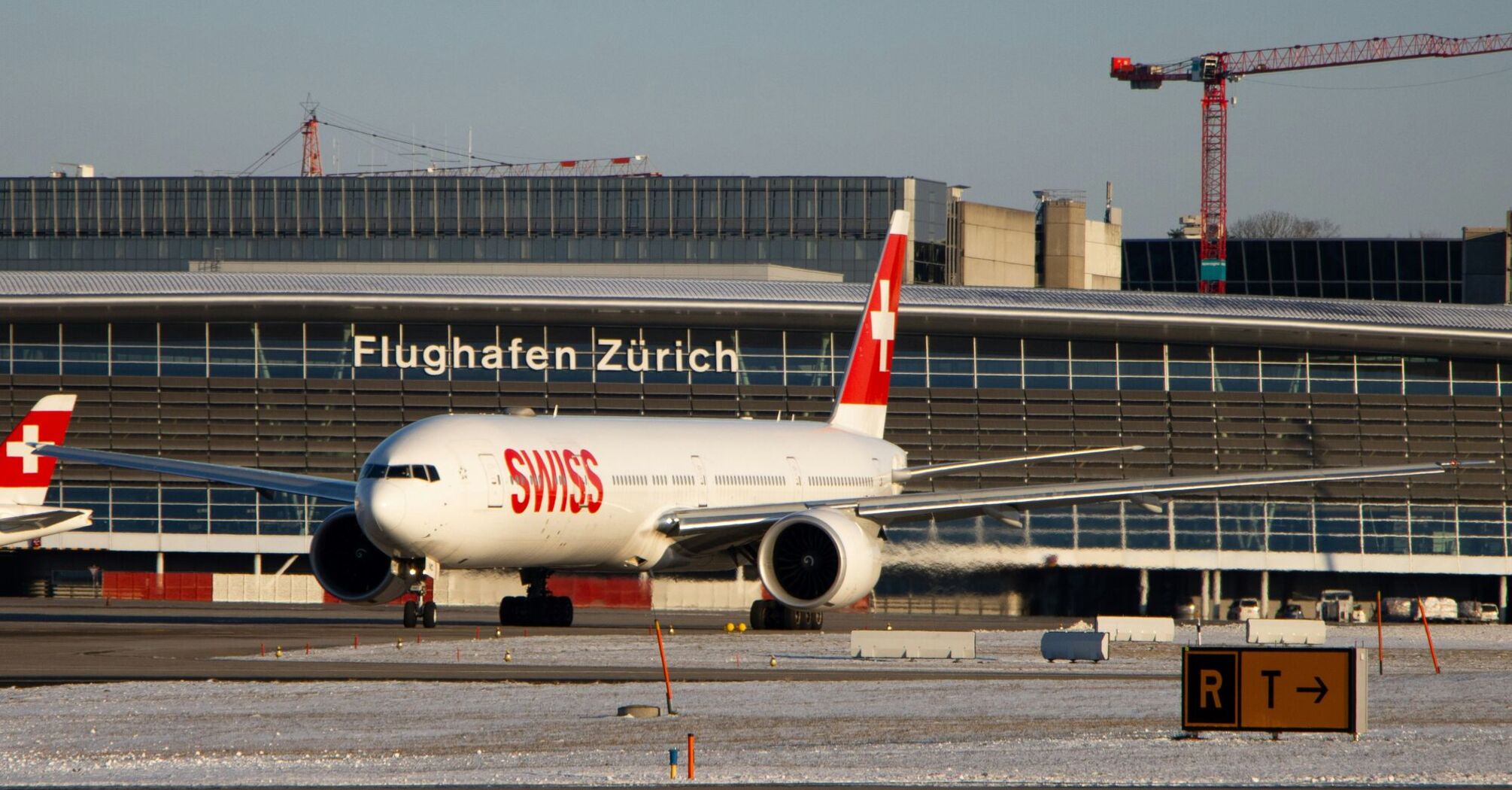 White and red Swiss Boeing 777 on airport during daytime