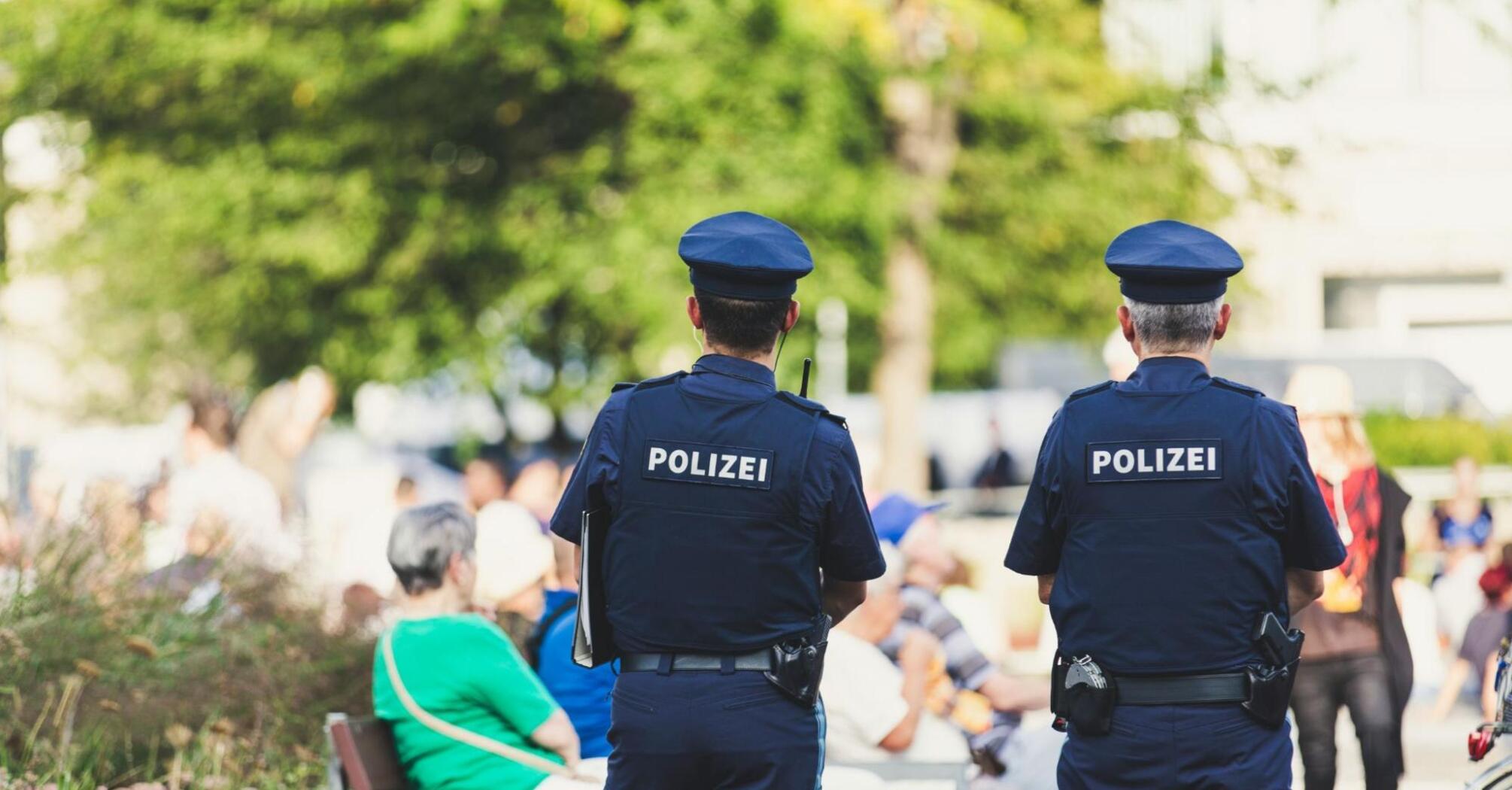 Two policemen stand and watch people