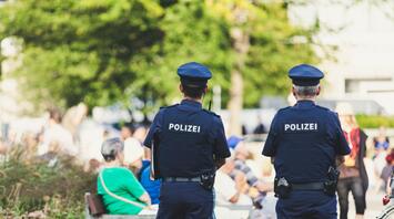 Two policemen stand and watch people