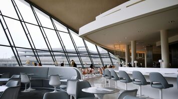 People sitting on white chairs inside airport lounge