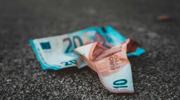 Crumpled euro banknotes on asphalt