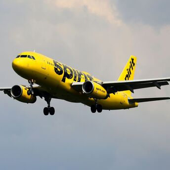A yellow and black airplane flying