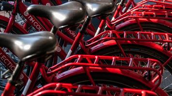 Bicycles with red frames stand in the parking lot