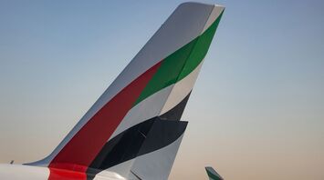 Close-up of Emirates aircraft tails at airport during sunset