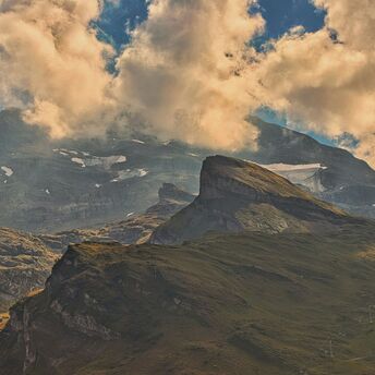 A view of a mountain range with clouds in the sky