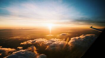 Sunset view from an airplane window above the clouds