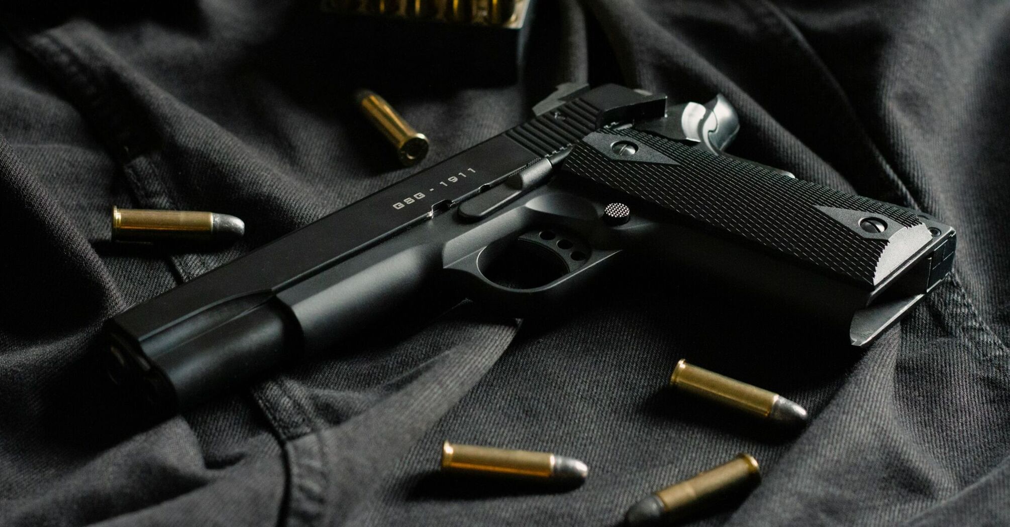 A black handgun with scattered bullets