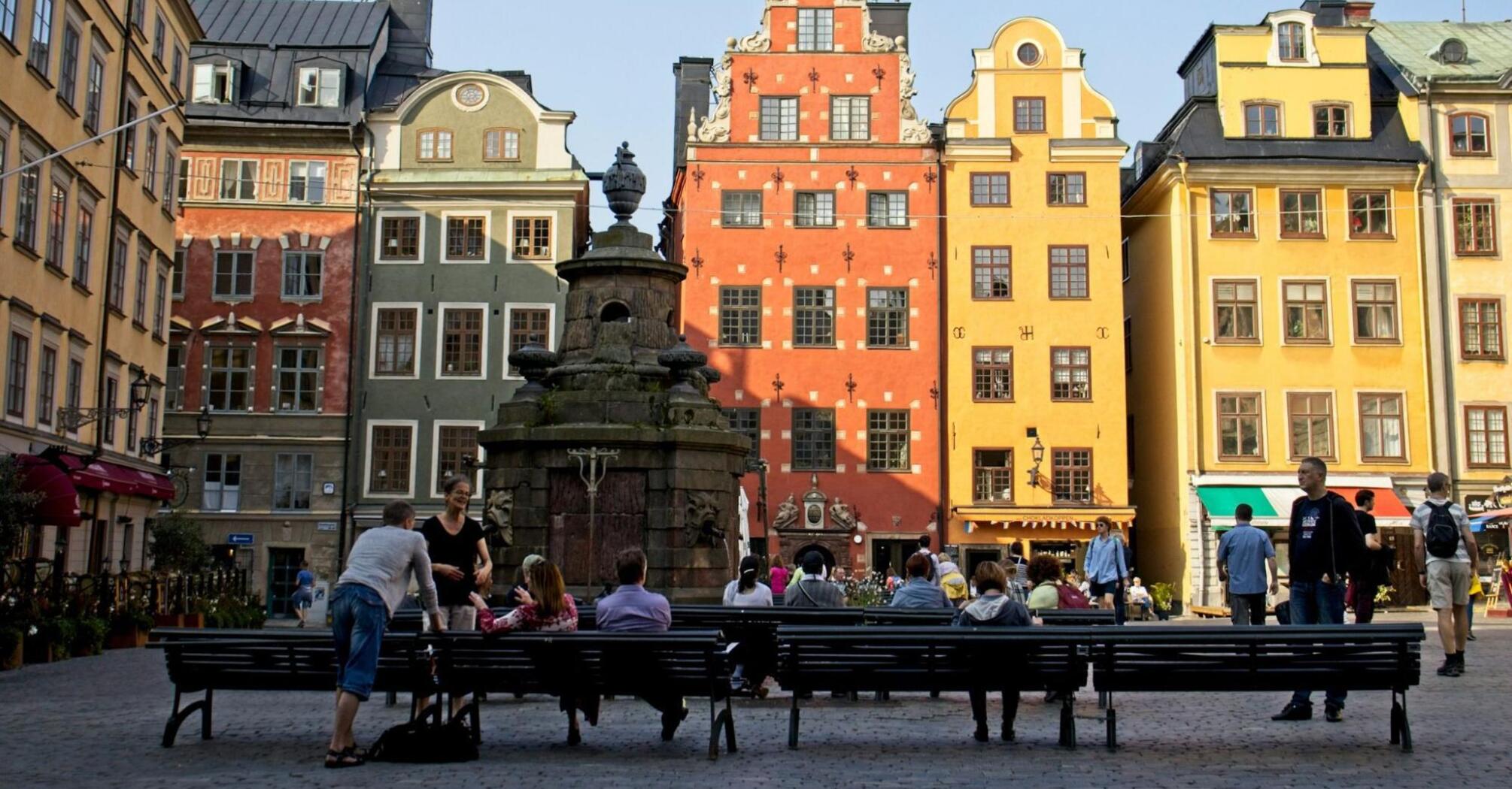 People sitting on the benches in front of building in Stockholm