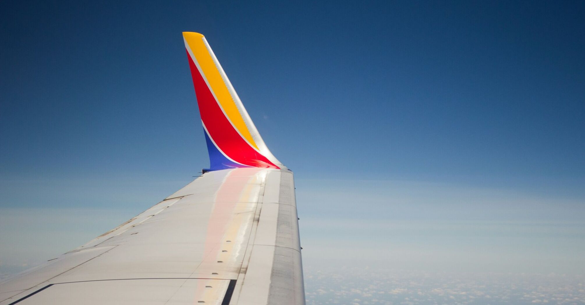 Southwest Airlines wing in flight over clouds