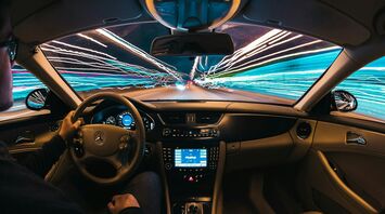 A driver at the wheel of a car with streaks of light representing speed and technology
