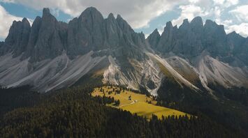 An aerial view of a Dolomites mountains range with trees