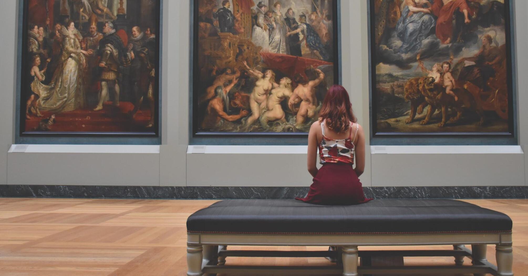 The girl looks at the three paintings of the painting