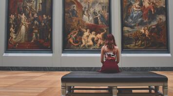 The girl looks at the three paintings of the painting