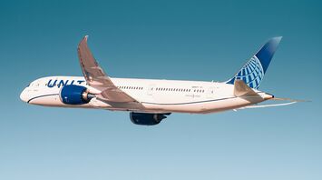 United Airlines plane in flight against a clear sky