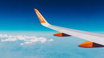 EasyJet airplane wing against blue sky and clouds