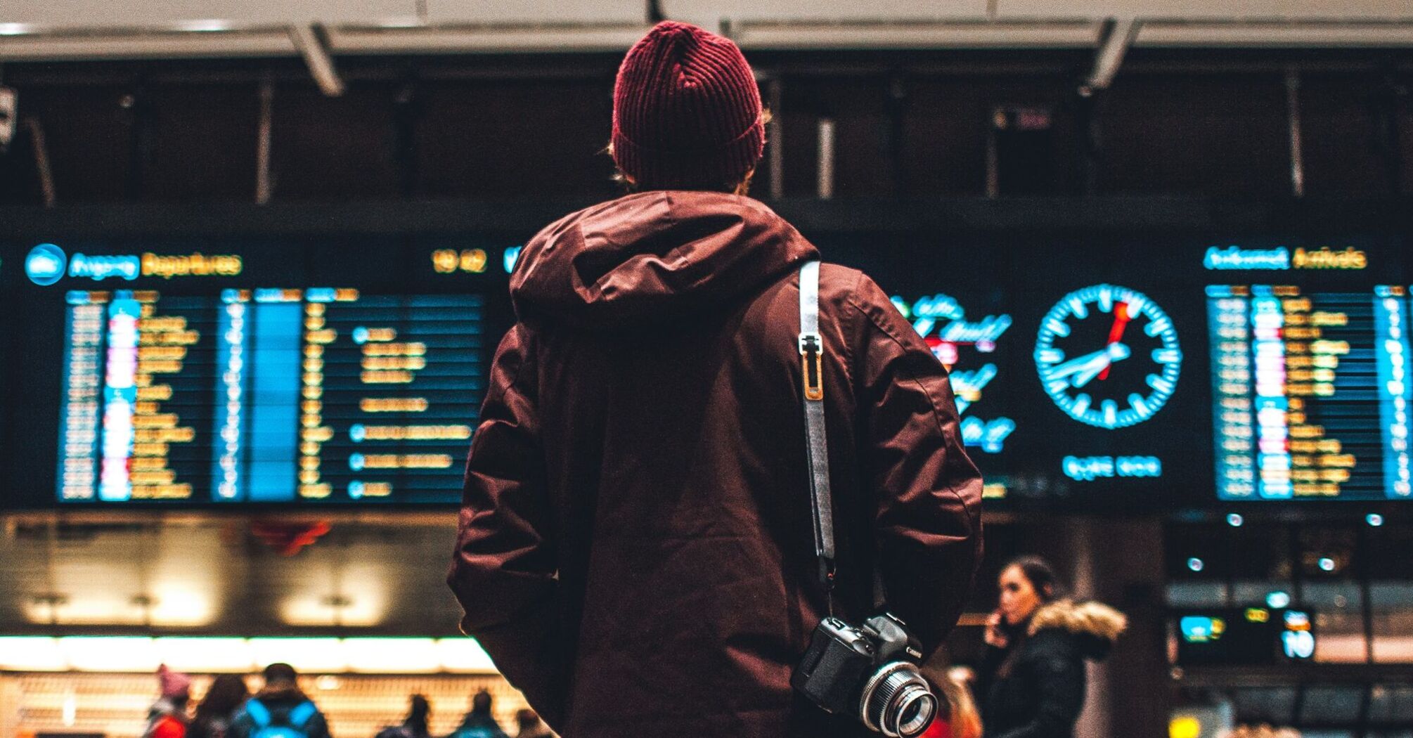 A traveler looking at departure boards in an airport