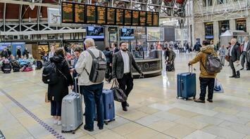 Travelers with luggage at a busy airport terminal