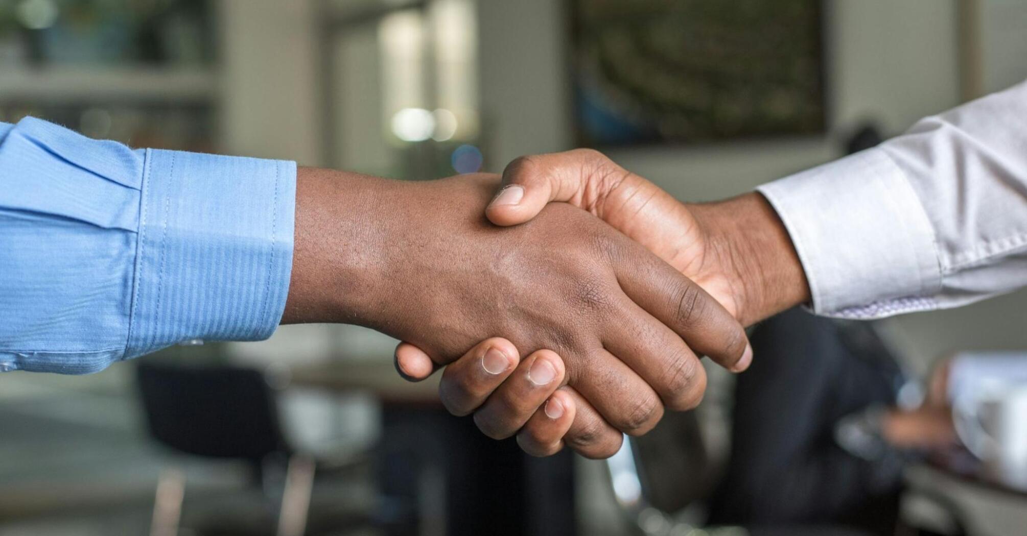 Handshake between two individuals in a business setting