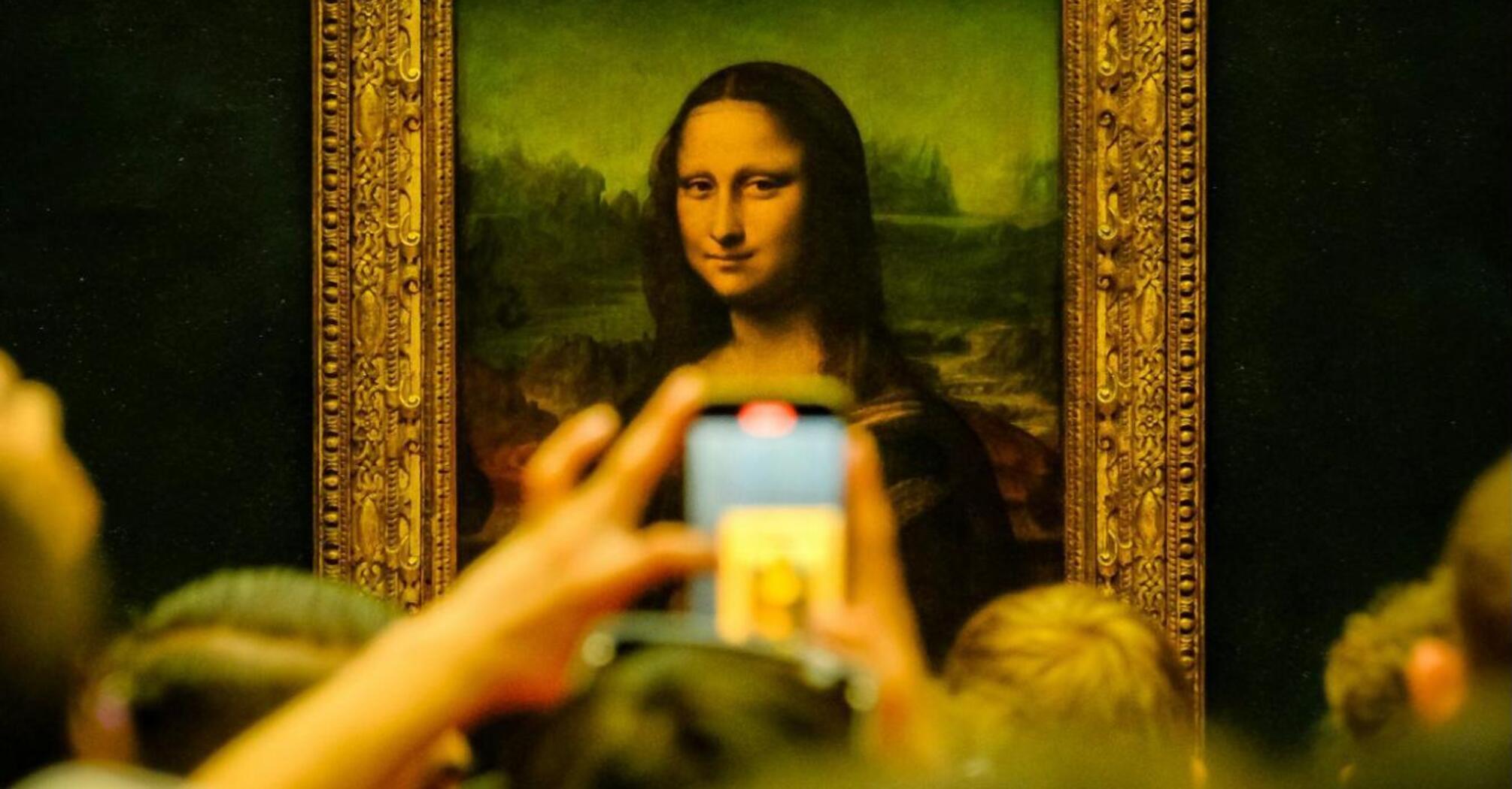 Tourists beside Mona Lisa in Louvre Museum