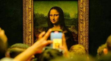 Tourists beside Mona Lisa in Louvre Museum