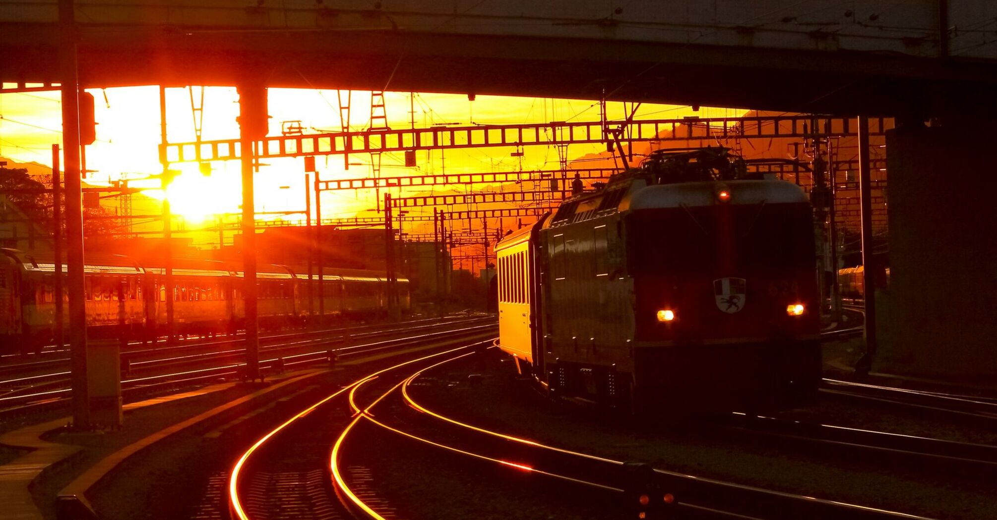 Train station at sunset with trains on the tracks