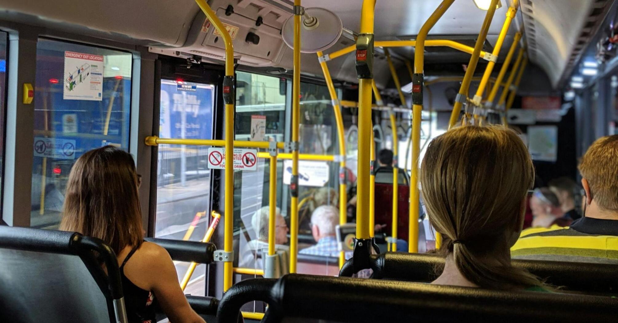 Interior of a bus with passengers seated and standing