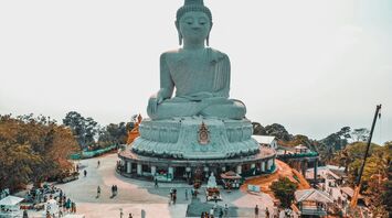 gray statue near green trees during daytime in Phuket