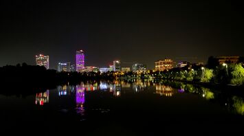 Night view of illuminated buildings reflecting on a lake in Bucharest, Romania