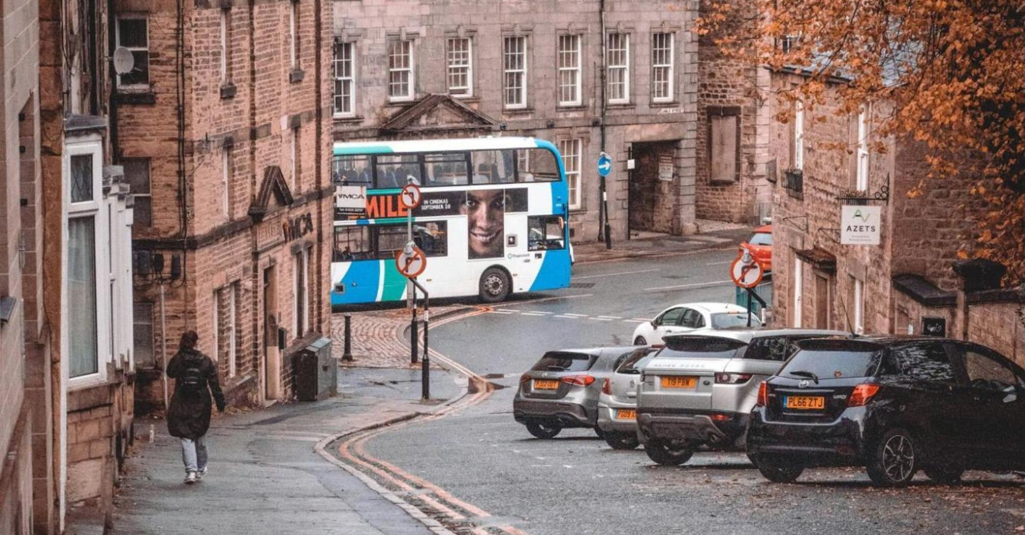 A double-decker bus turning a corner in a quaint Lancashire town