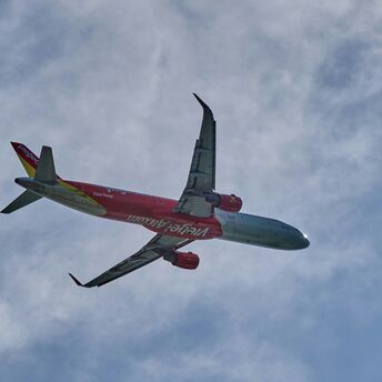 red and white vietjetair airplane flying in the sky