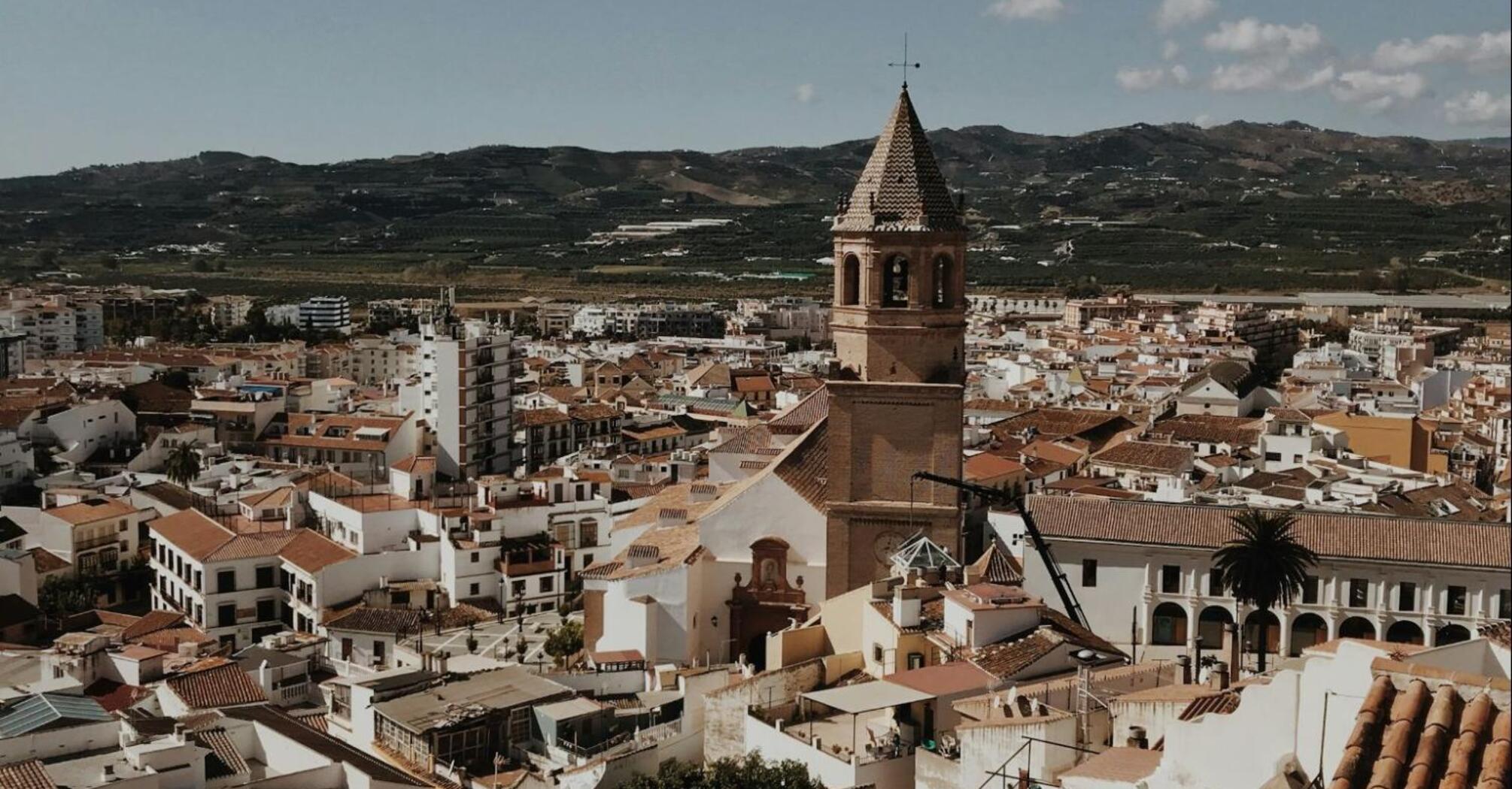 Aerial view of Vélez-Málaga with a prominent church tower and surrounding buildings